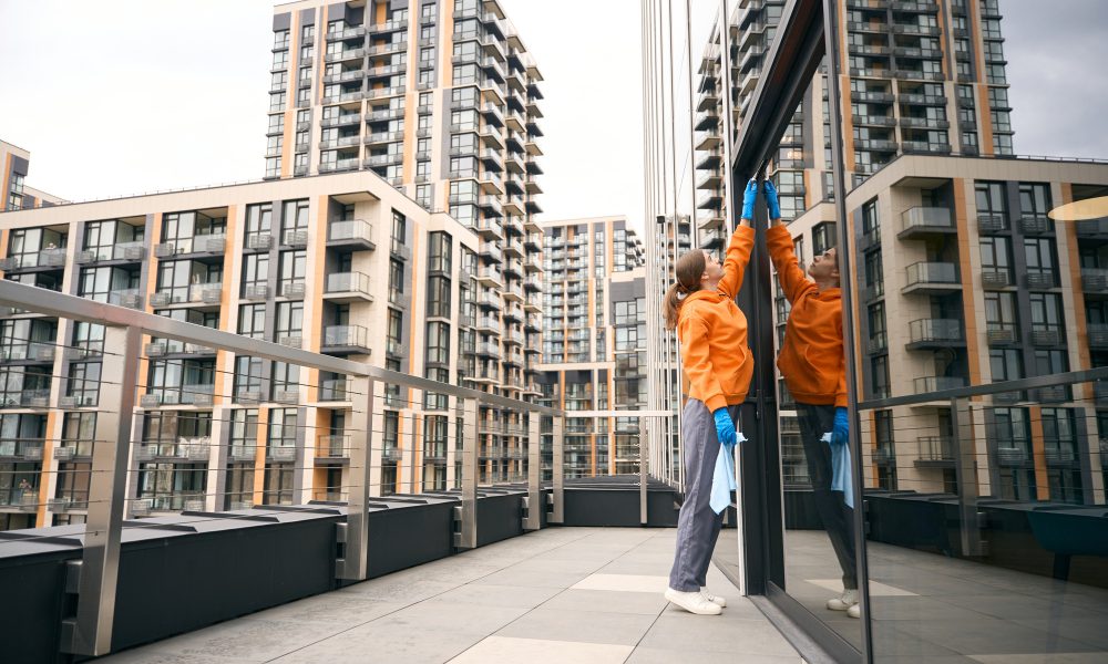 Cleaning lady cleans windows office center she is in comfortable uniform