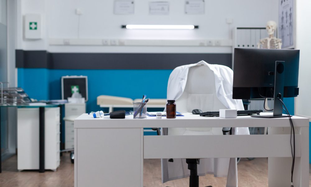 Empty medical office equipped with modern furniture ready for clinical examination. Hospital workplace with nobody in it having disease documents on table. Medicine services
