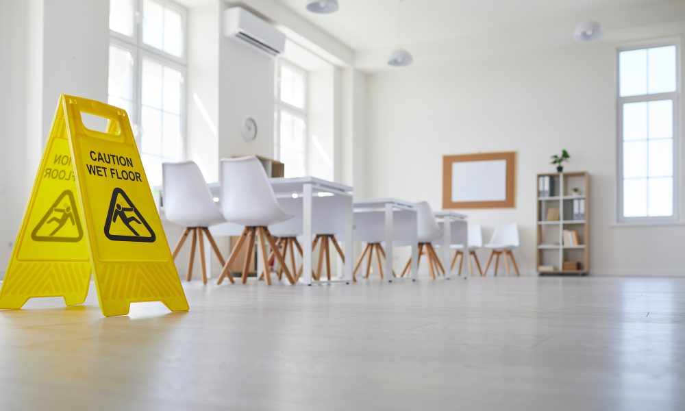 School classroom where cleaning service worker placed sign which reads Caution Wet Floor