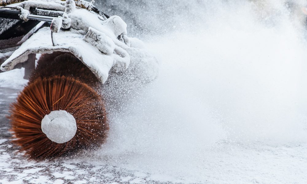 Snow plow does removal after blizzard in winter. Snow blower in motorway. Winter service on road