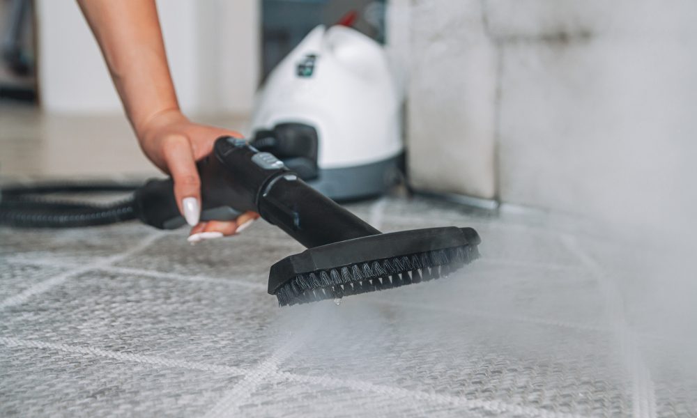 Woman cleaning carpet with a steam cleaner
